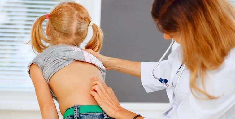 doctor examines child's back for back pain
